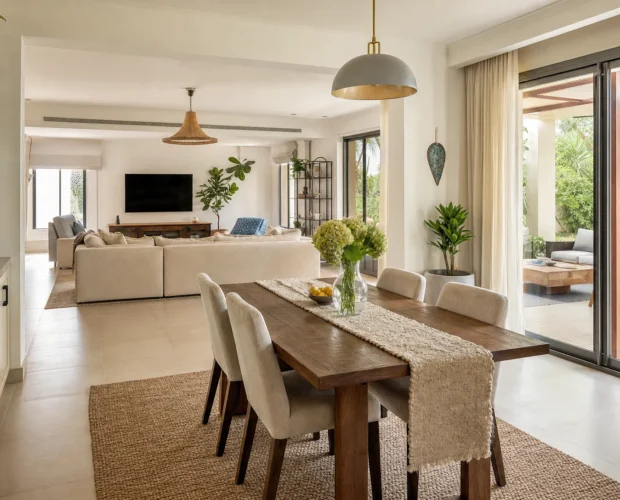 A refurbished UAE villa living and dining area opens toward a shaded outdoor sitting space.